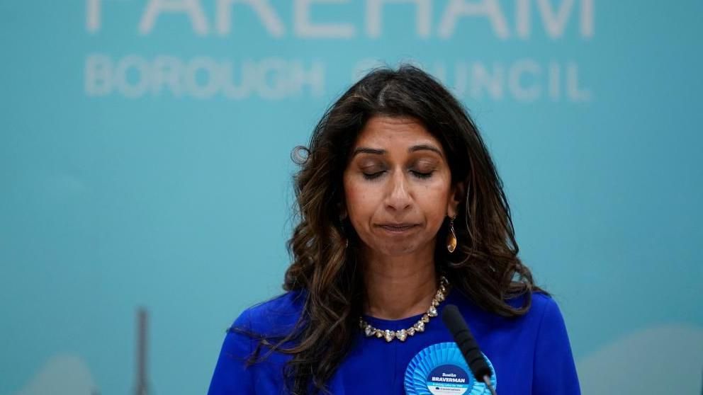 Suella Braverman with her eyes closed giving a speech in front of a wall with Fareham Borough Council written on it