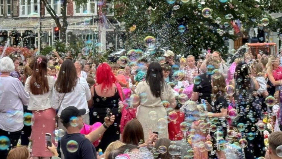 Bubble blowing event held in Southport - crowds surrounded by bubbles look into the sky