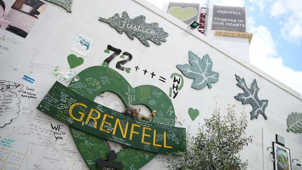 A memorial wall for the victims of the Grenfell Tower fire, positioned at the foot of the tower