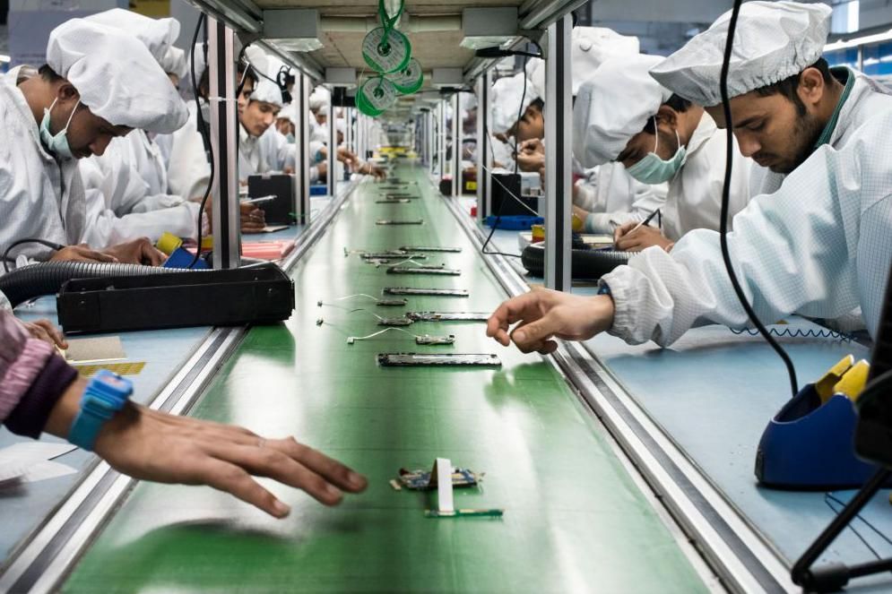 Workers assemble smartphones on the production line inside the Intex Technologies brand plant in Noida. 