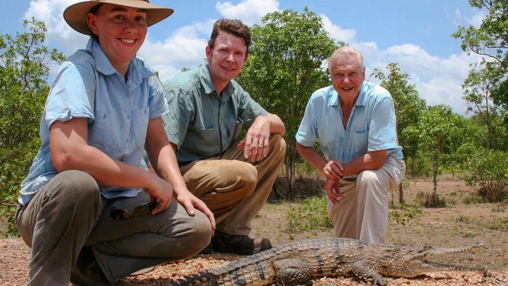 Erin and Adam Britton pose with David Attenborough and a crocodile