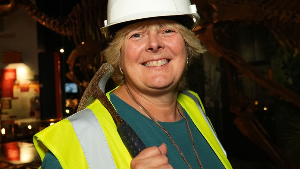 Cindy Howells in front of a dinosaur at the museum