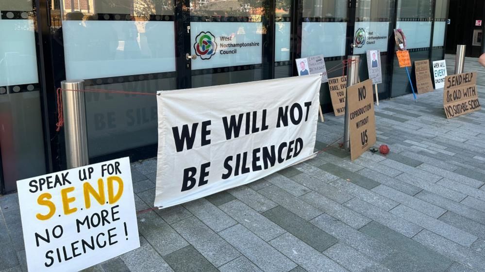 Placards and banners positioned outside West Northamptonshire Council's offices