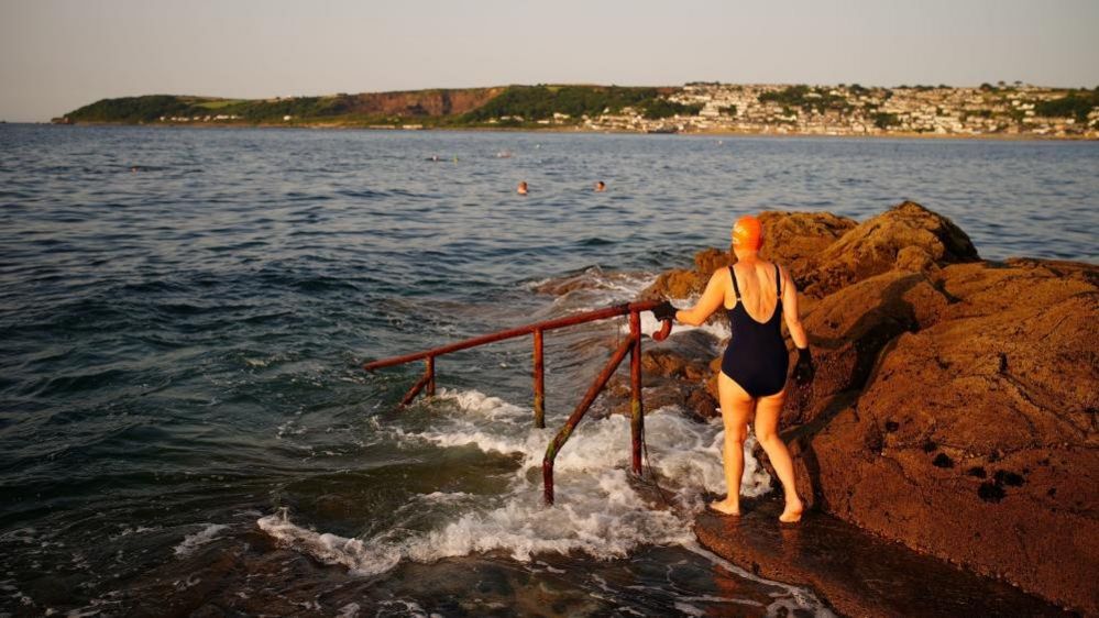 People preparing to enter the water in Penzance, Cornwall