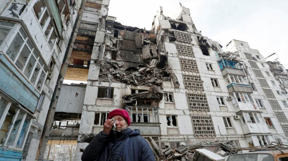 Valentina Demura, 70, reacts next to the building where her apartment, destroyed during Ukraine-Russia conflict, is located in the besieged southern port city of Mariupol, Ukraine March 27, 2022.