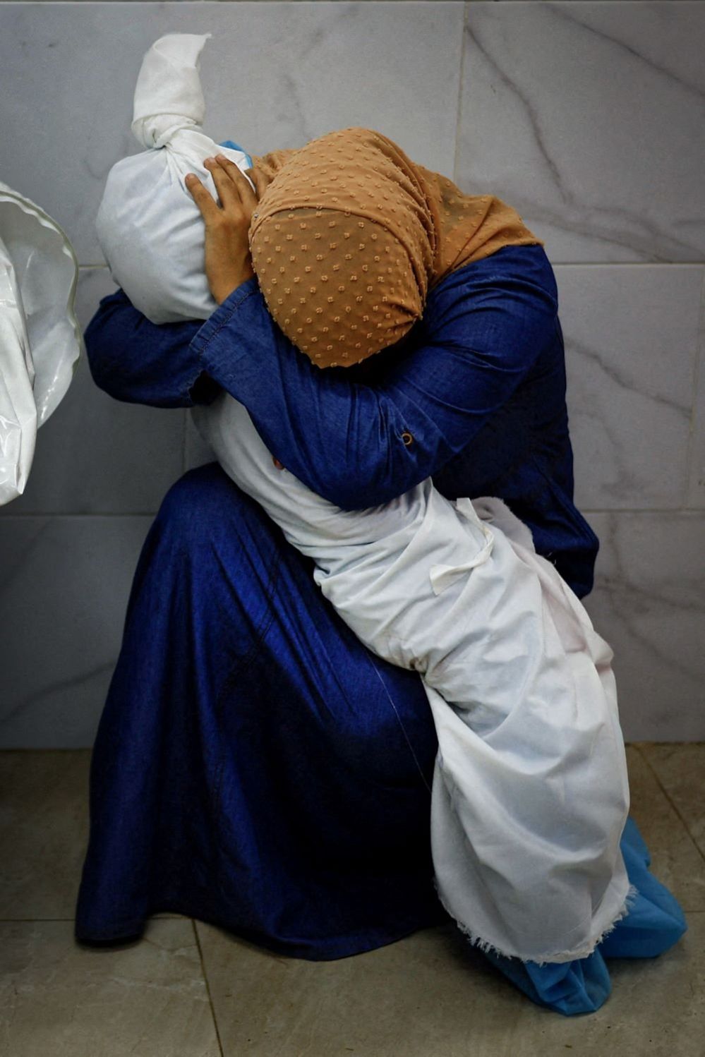 Inas Abu Maamar cradles the body of her niece Saly, 17 October 2023