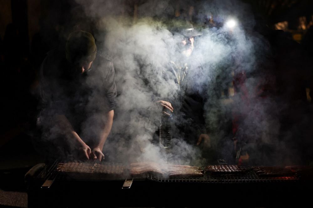 French farmers cook food on a barbecue, by a blockade on the A16 near Esches, France