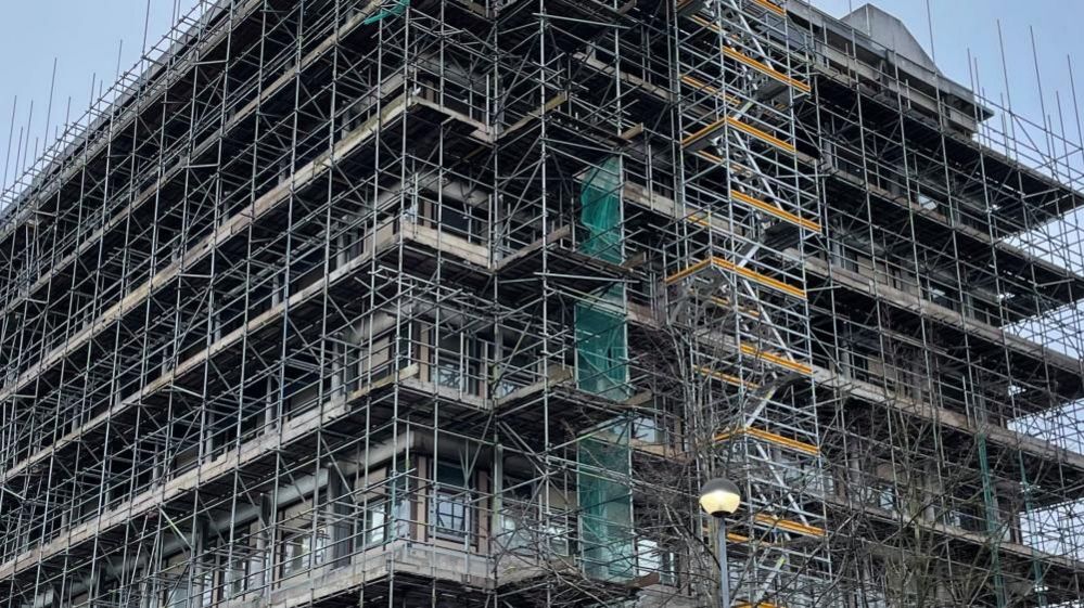 Close view of concrete tower block, showing scaffolding