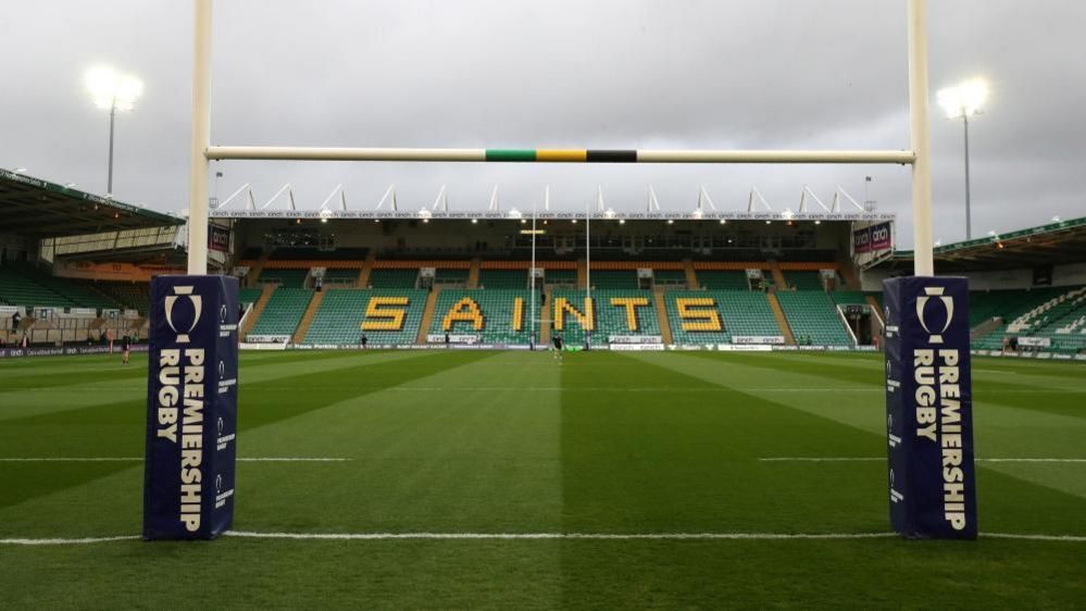 Rugby stadium with posts in foreground and seating with "Saints" spelt out in yellow