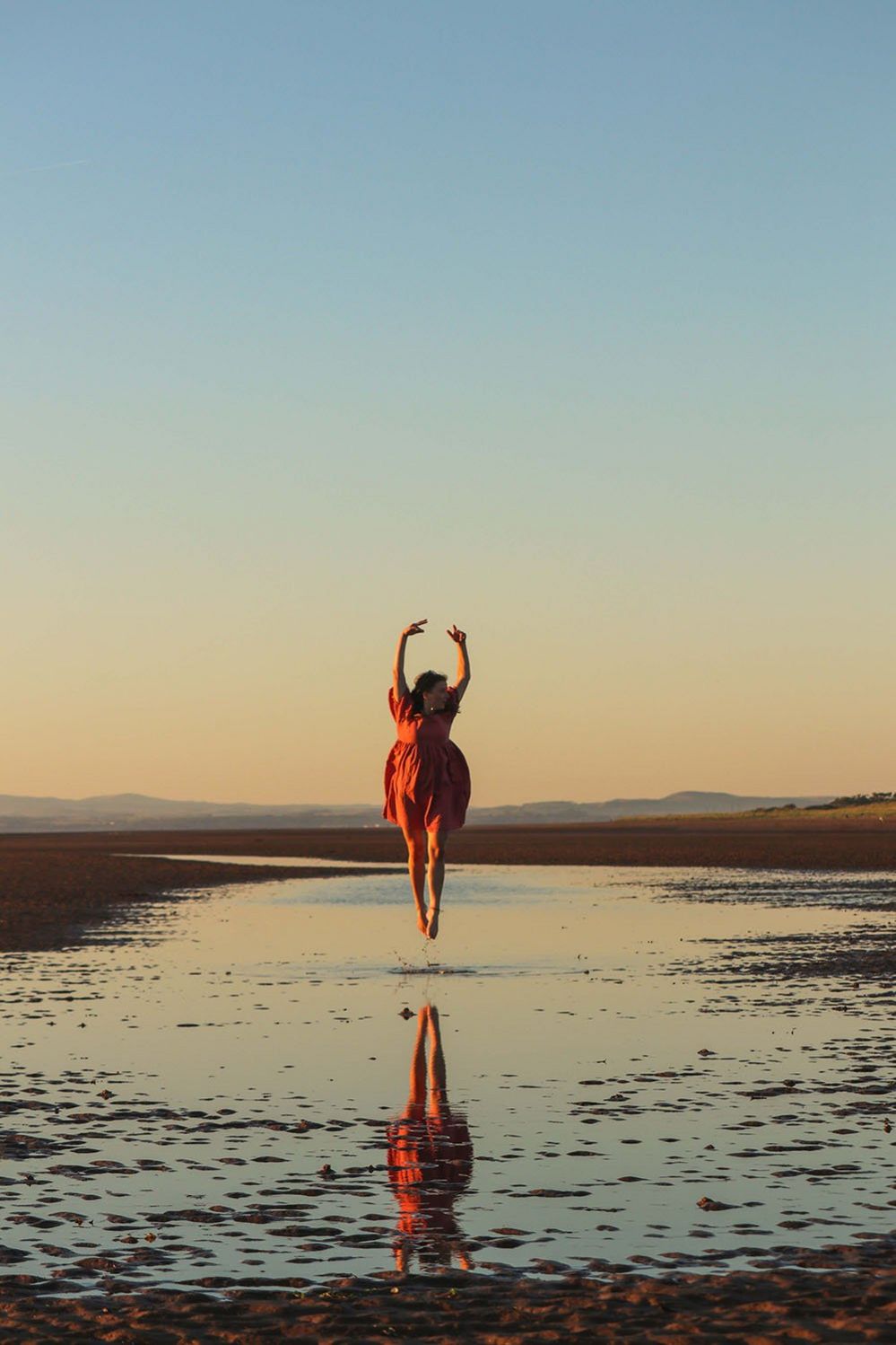 Женщина прыгает на пляже