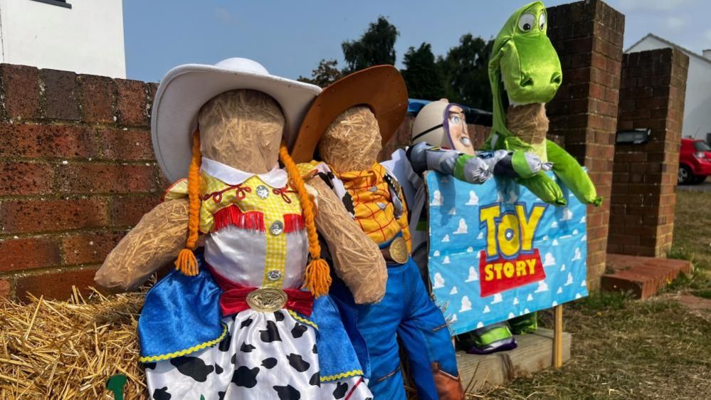 Four scarecrow characters from Toy Story, including Jessie, Woody, Buzz Lightyear and Rex