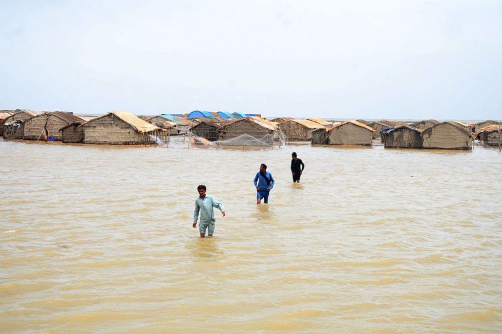 People affected by the cyclone wade through water