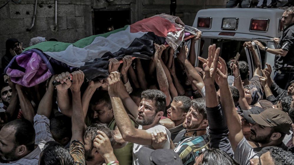 Palestinian mourners carry the body of Razan al-Najar during her funeral in Khan Younis, southern Gaza Strip, 2 June 2018