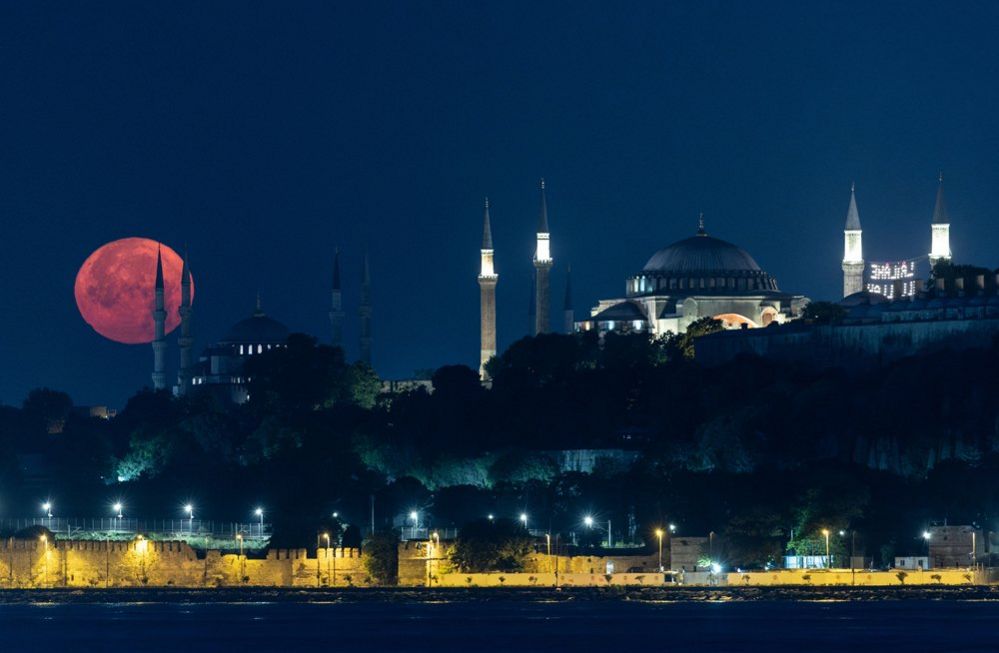 La luna piena tramonta dietro la Moschea Blu e la Grande Moschea di Santa Sofia, a Istanbul, Turchia, 03 luglio 2023