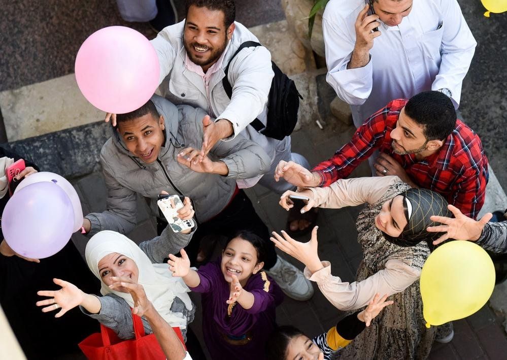 People attempt to catch balloons in Cairo