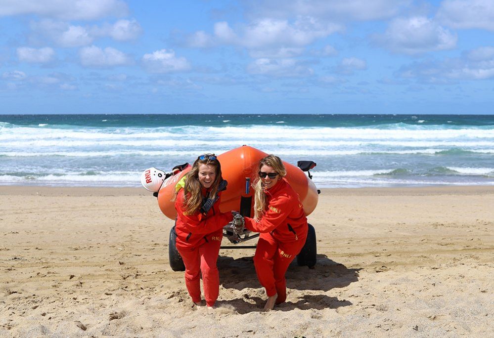 Women pull a lifeboat up the beach