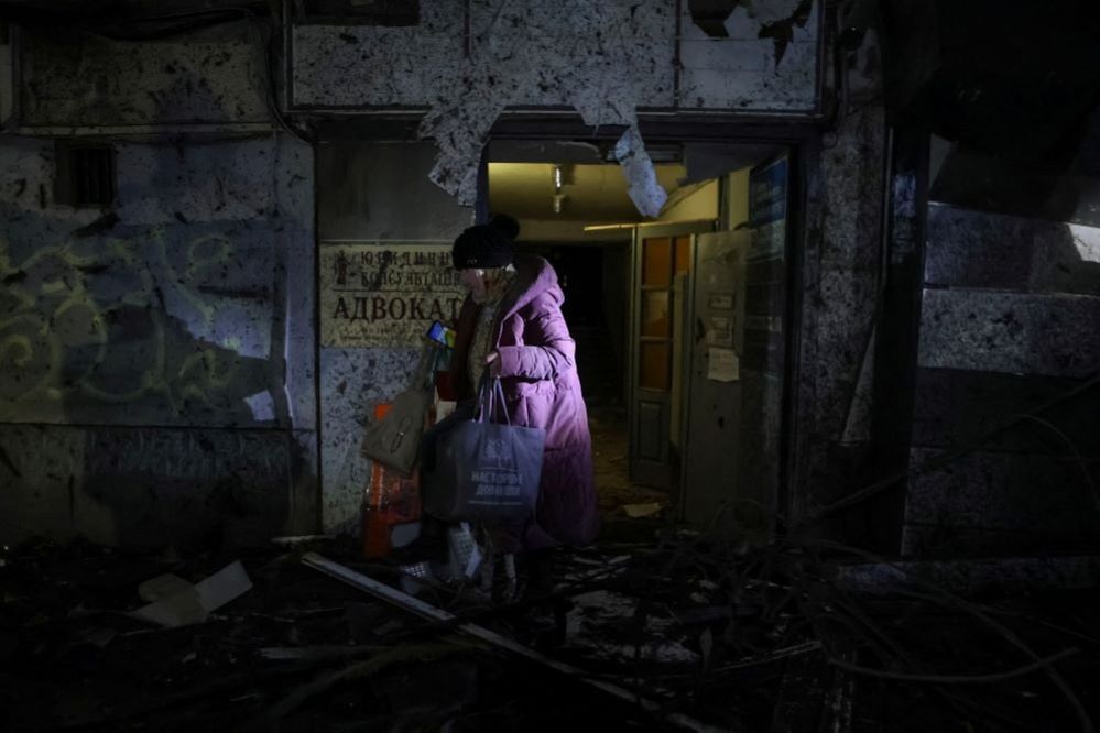 A resident leaves a damaged building in Kharkiv, Ukraine