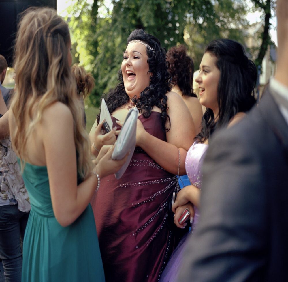 Shannon laughing and joking with friends at her school prom