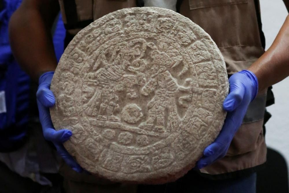 Рабочий показывает круглое табло майя, используемое для игры в мяч, найденное на археологических раскопках в Чичен-Ице во время пресс-конференции в Мериде, Мексика, 11 апреля 2023 года.