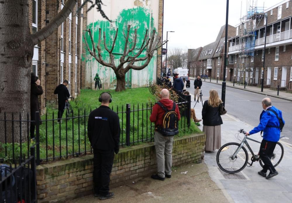 A Banksy mural near a tree on Hornsey Road in the Finsbury Park area of London
