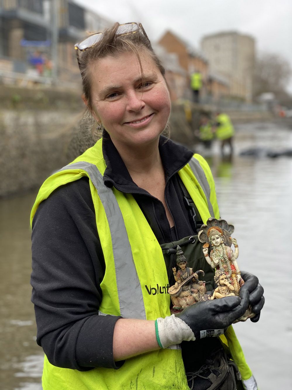 Monika Buttling-Smith holding three Hindu gods found into the canal