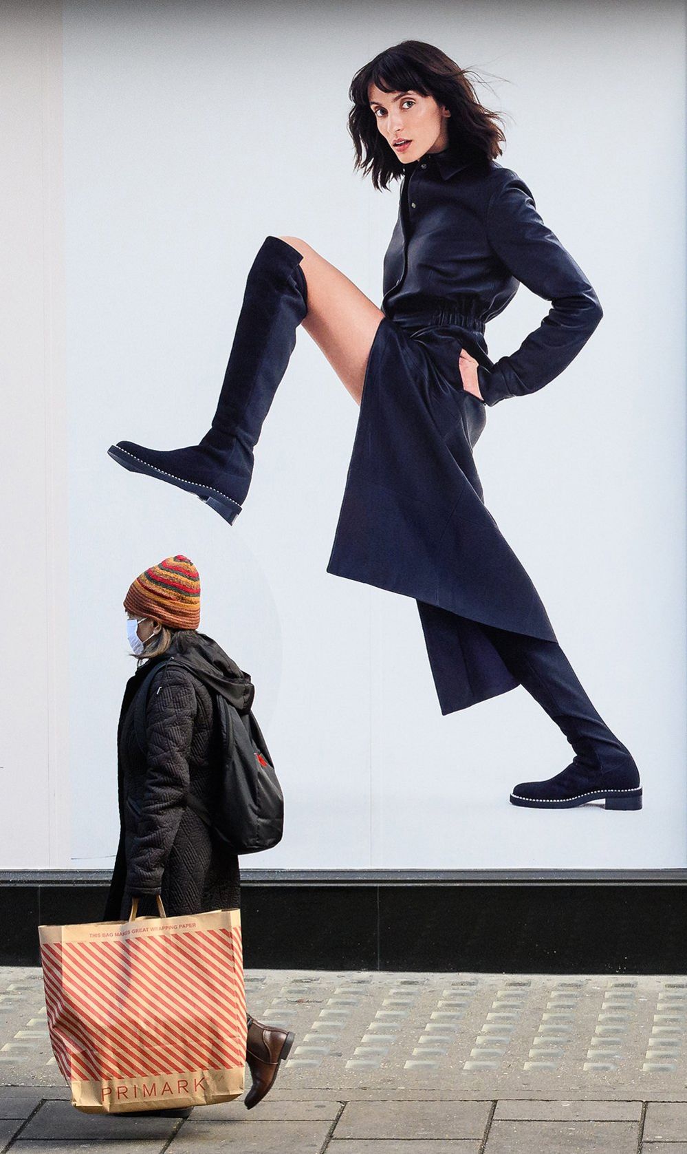 A model in an advertisement appears to step on shopper