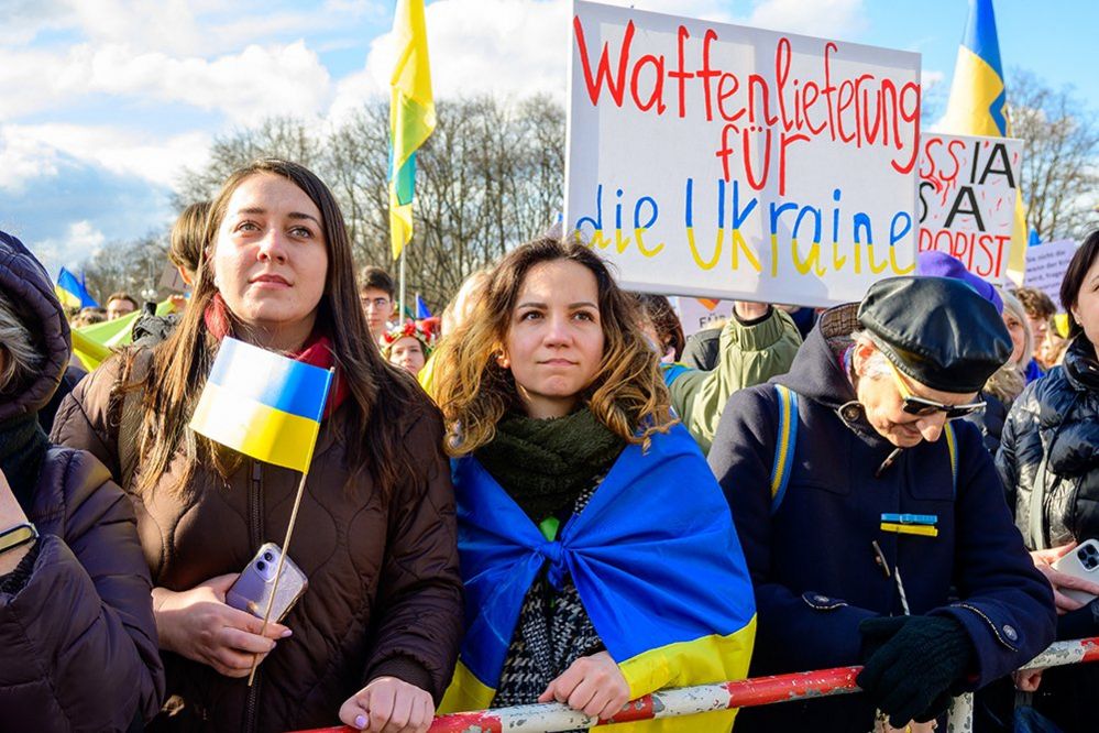 women hold Ukrain flags at a protest