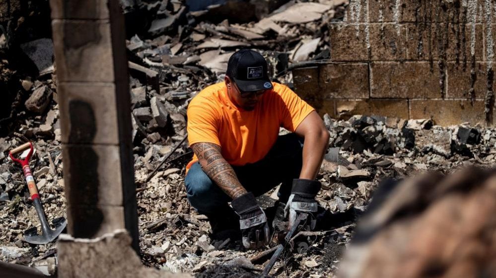 A man sits in the rubble of what once was his bedroom destroyed by a wild fire in Lahaina, Hawaii, USA, 11 August 2023.