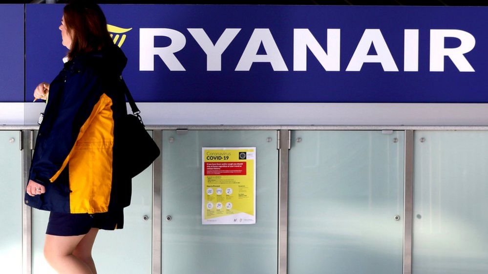 Woman walks past Ryanair sign
