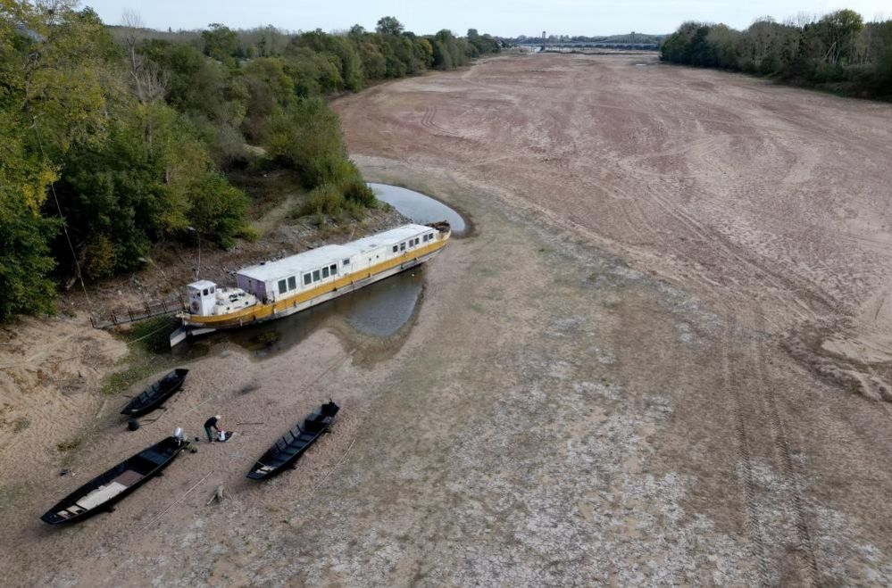 A barge surrounded by sandbanks in a branch of the Loire River in Loireauxence, France