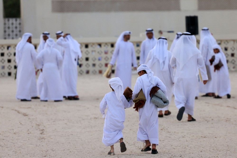People exchange wishes after Eid al-Adha morning prayers at Dubai's main mosque in the United Arab Emirates