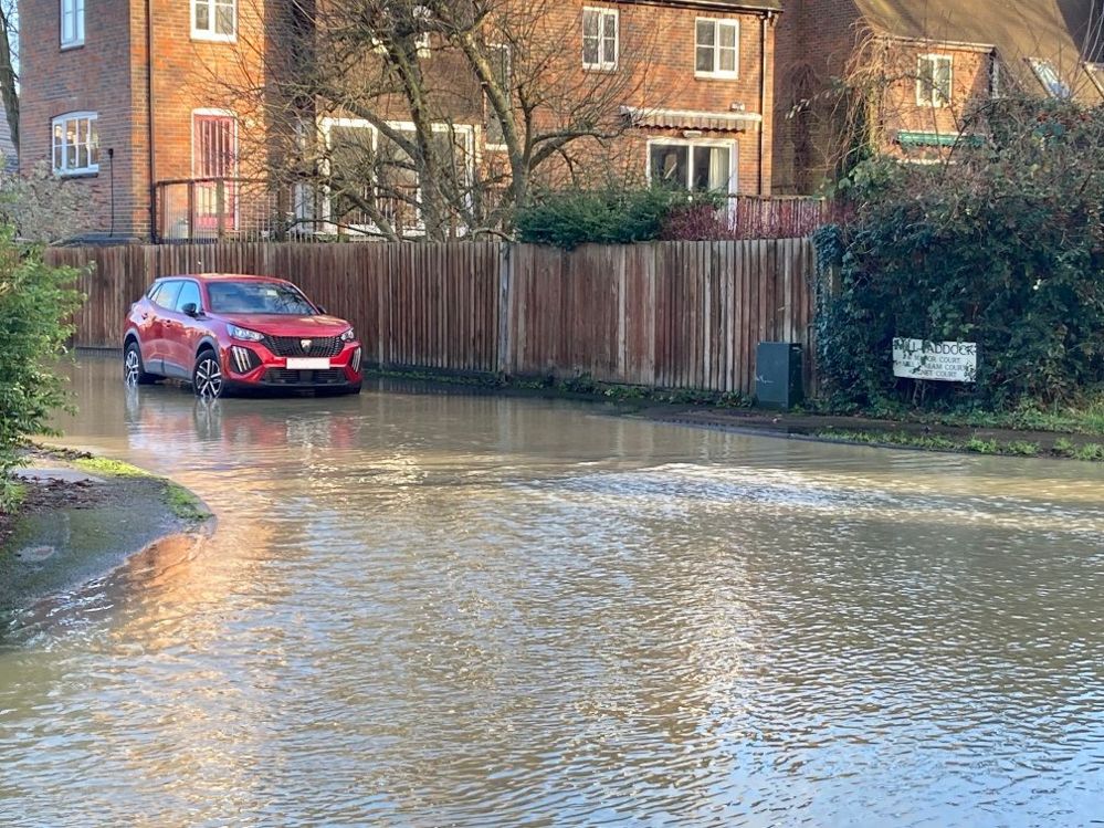 A car on the edge of a flooded road