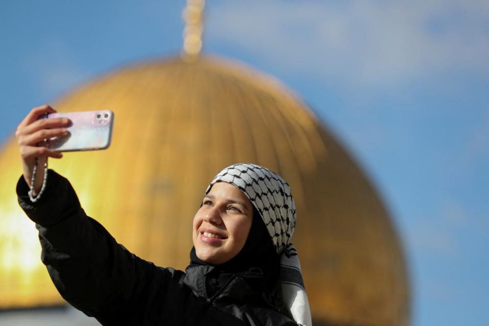 A Palestinian woman takes a selfie