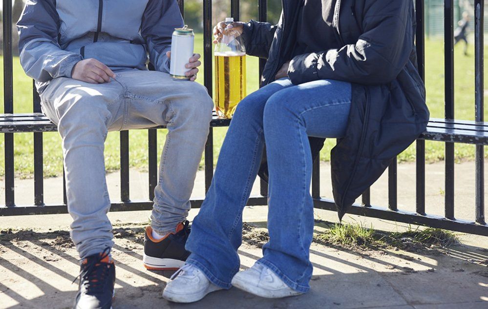 Teenagers drinking alcohol in a park