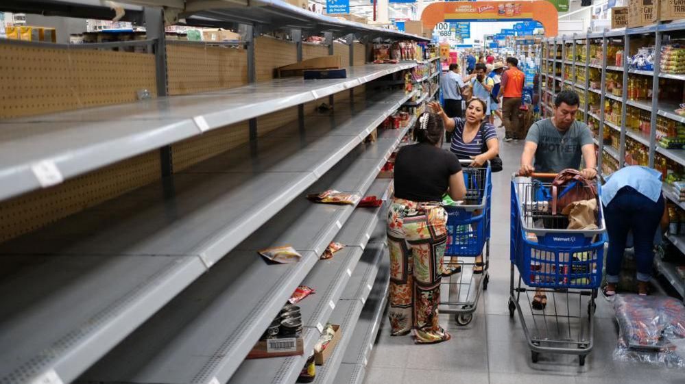 People pictured near partially empty shelves for non-perishable food at a supermarket ahead of the arrival of Hurricane Beryl, in Cancun, Mexico July 2, 2024