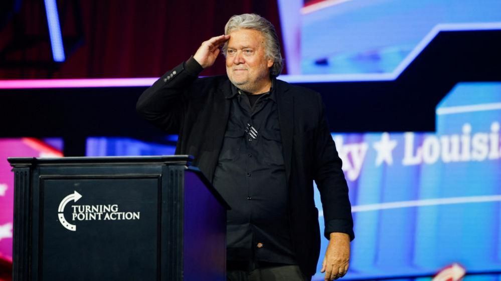Bannon saluting on stage at a conservative political conference in June 2024