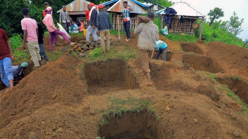 Relatives of the victims of a landslide dig graves near the accident site in the Kencho Sacha Gozdi district, Gofa Zone, southern Ethiopia, 24 July 2024