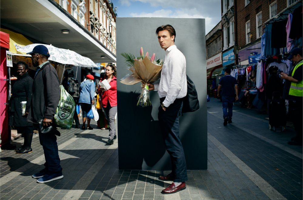 Portrait of a man in the street holding a bunch of flowers
