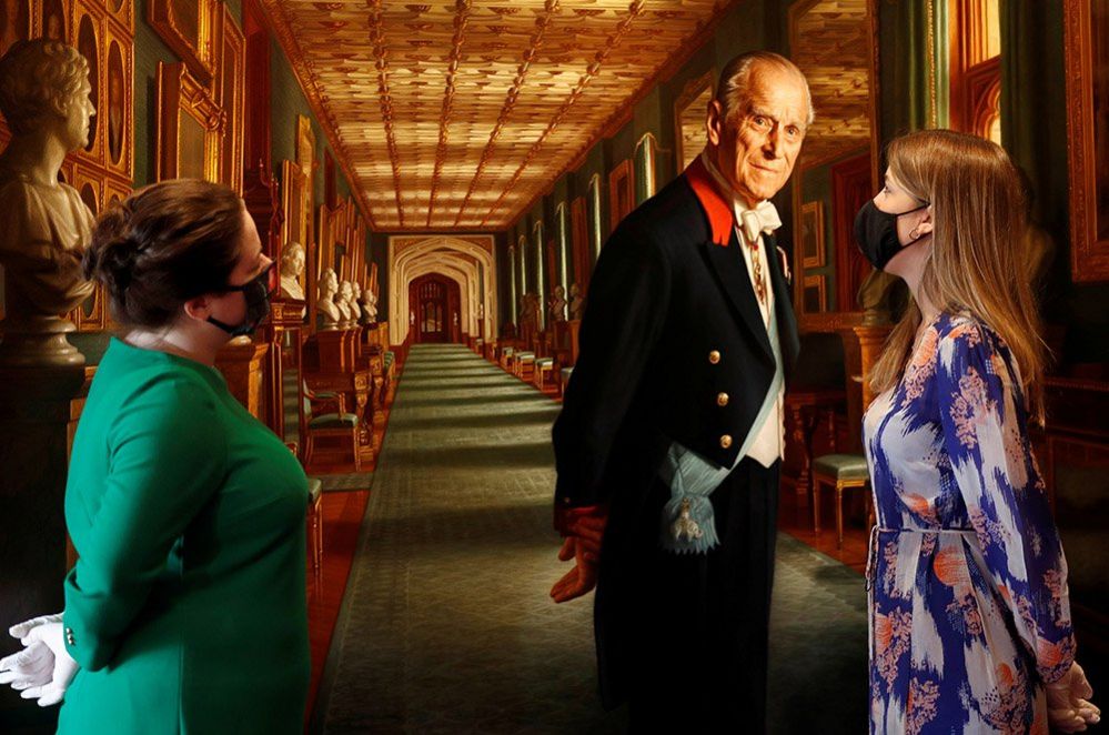 Members of the Royal Collection Trust staff pose for a photograph with a portrait of the Duke of Edinburgh