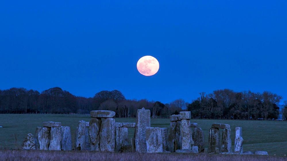 Stonehenge pictured with a full moon "floating" over it