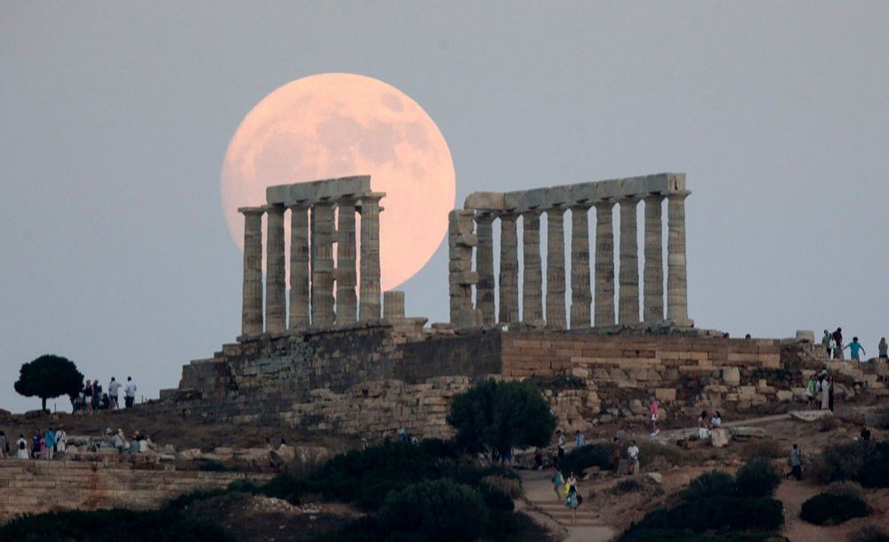 La luna llena se eleva por encima del Antiguo Templo de Poseidón en el Cabo Sounion, en Sounion, Grecia, el 2 de julio de 2023
