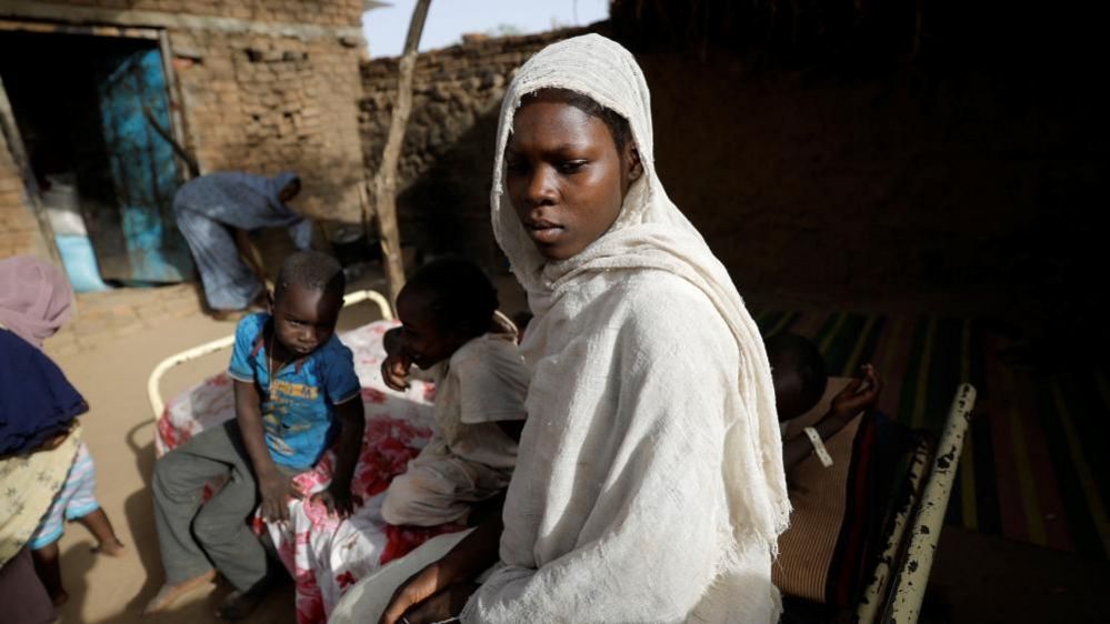 A woman who fled the war in Sudan sits at a family's home in Chad