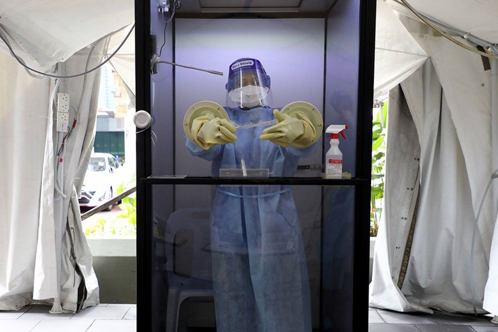 A doctor waits inside a protective chamber