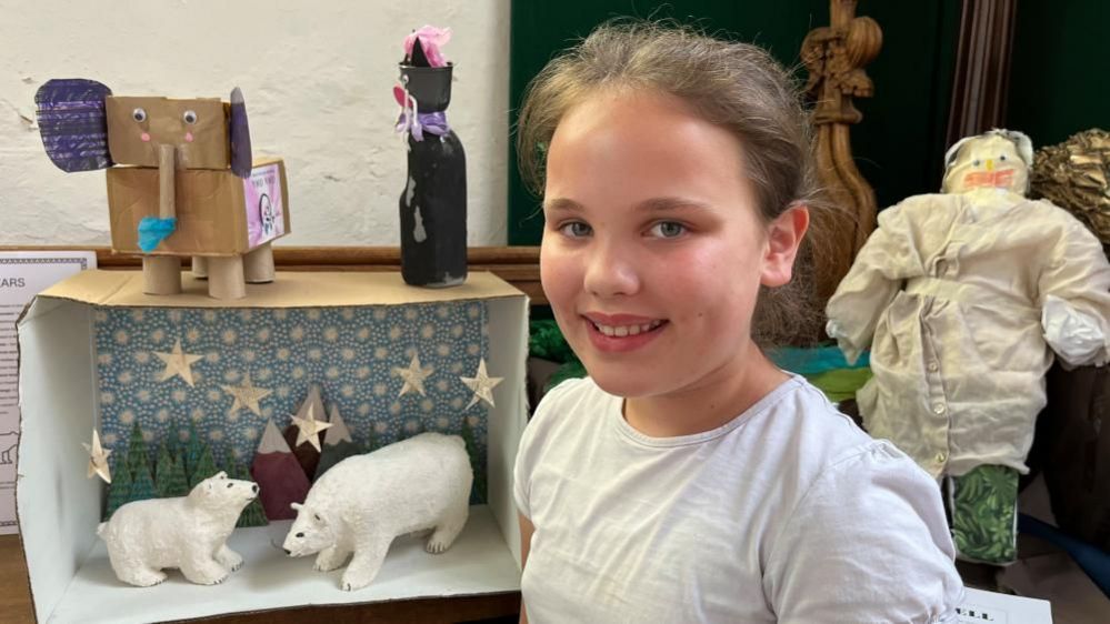 Lucy standing near her sculpture of two polar bears