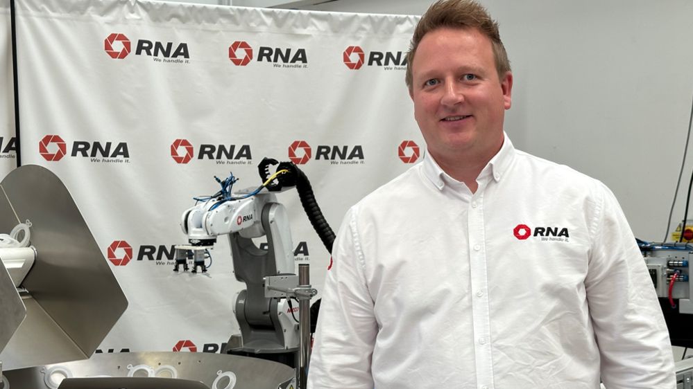 Man in white shirt standing in front of industrial equipment