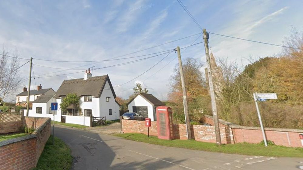 Clay Coton, showing a thatched house, a phone box and a signpost