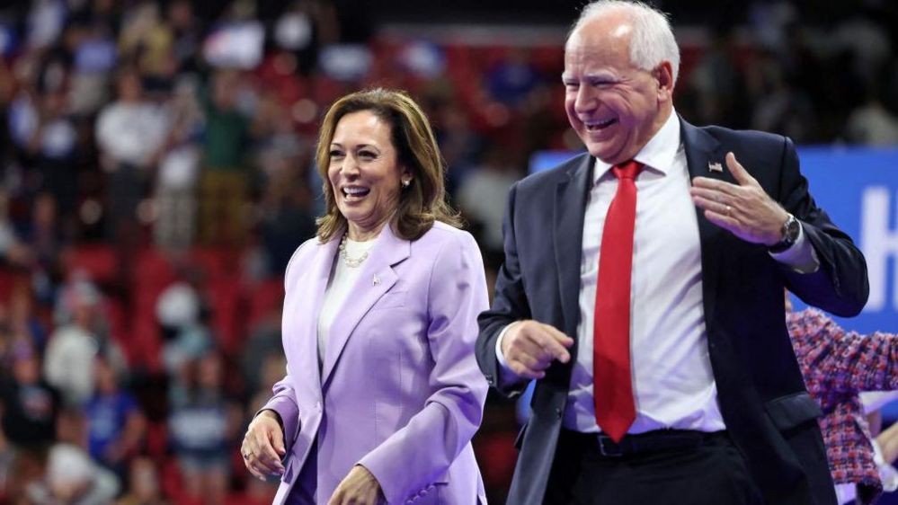 Kamala Harris (L) and Minnesota Governor  Tim Walz gesture during a campaign rally in Las Vegas, Nevada