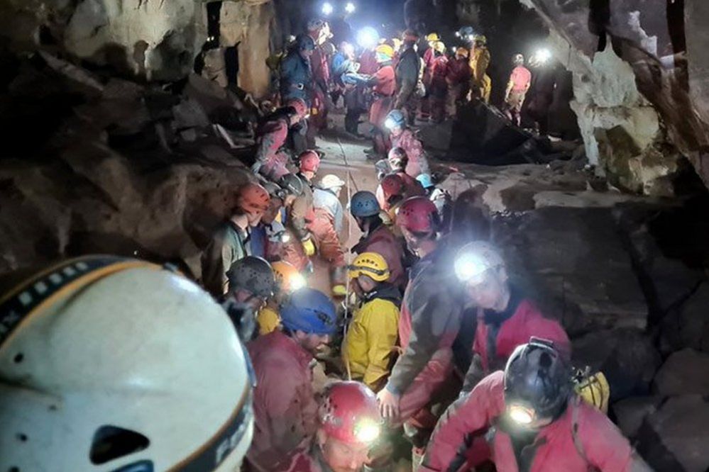 Rescue team carrying injured caver on a stretcher through a cave, 8 November 2021