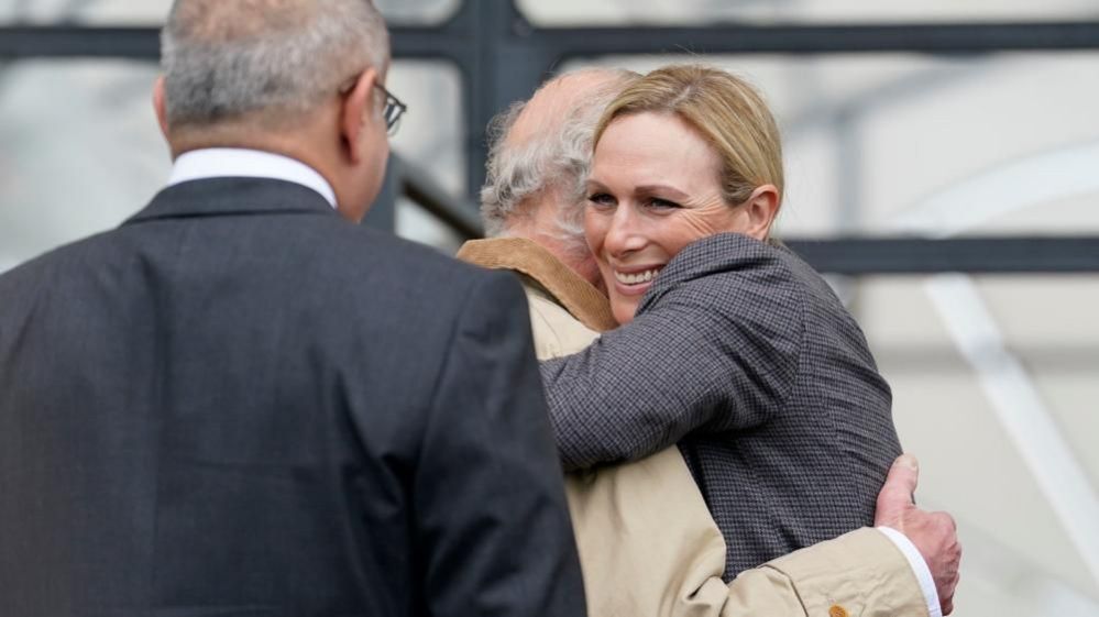 Zara Tindall smiles as she hugs her uncle King Charles