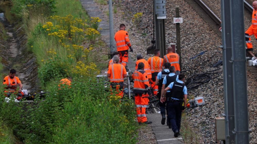 SNCF railway workers and law enforcement officers work at the site where vandals targeted France's high-speed train network with a series of coordinated actions that brought major disruption, ahead of the Paris 2024 Olympics opening ceremony, in Croisilles